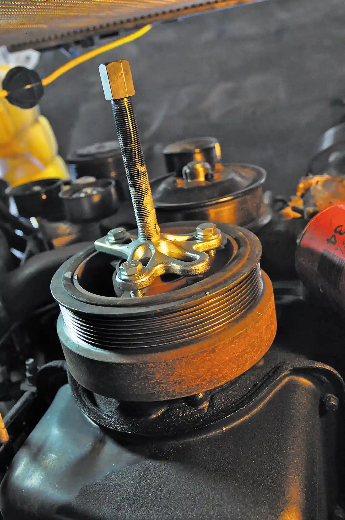 4. The balancer is also pressed onto the crankshaft, so it will not just slide right off once the bolt has been removed. A three-prong puller must be used.