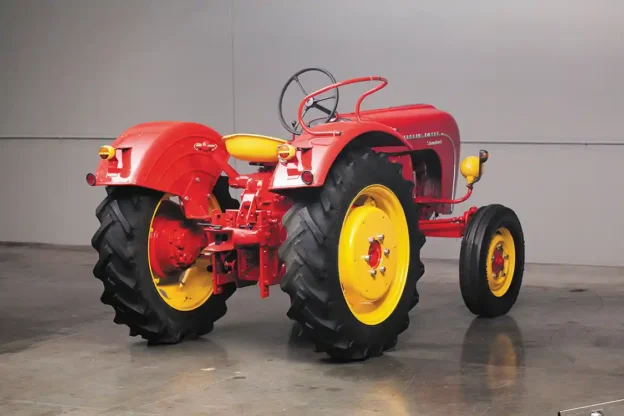 Though a rear three-point hydraulic lift was technically optional, it was so common in the U.S. imports that you could say “every one” had it. This one is missing its lower arms and links but has the adjustable hitch. For the Standard, the lift was a Class II and rated for about 2,800 lbs. The specs say this tractor was rated for a 2-14 mouldboard plow. When you look at specs for the four Porsche-Diesel tractor models, the plow rating is tied directly to the number of engine cylinders, in this case: two bottom for two cylinders. The hoop-like device on the rear fender is the passenger seating area. Not comfortable, but secure.
