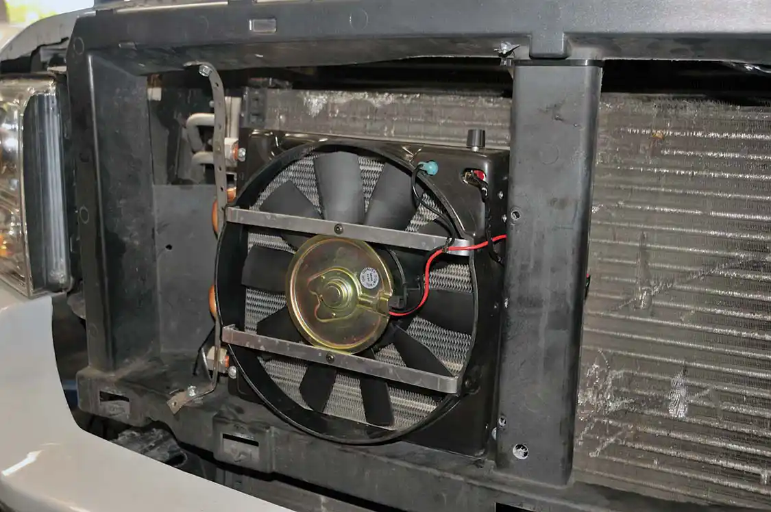15. Next came the Flex-a-Lite Transmission Cooler. After removing the factory grille to gain access the cooler/fan combo was mounted right in front of the radiator with some straps. The cooler can be mounted anywhere and the fan can run in either direction.