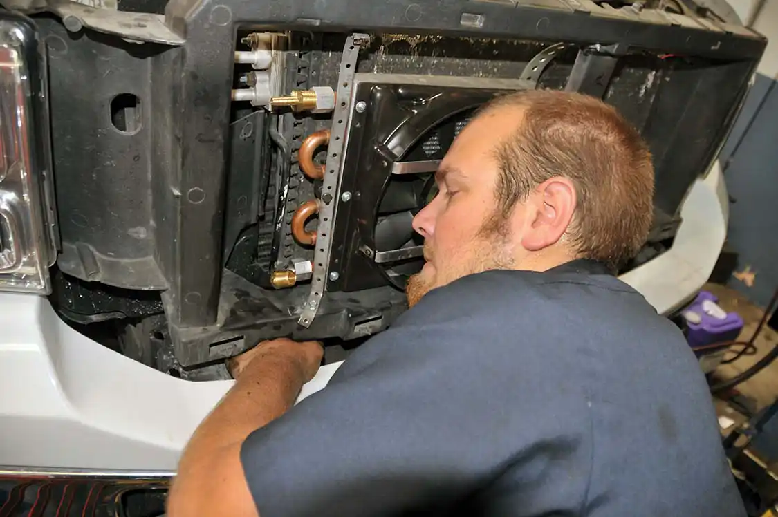 18. Running the lines between the cooler and the connections made on the factory transmission cooler lines came next. Cory fished the rubber lines between the frame rails to the cooler.
