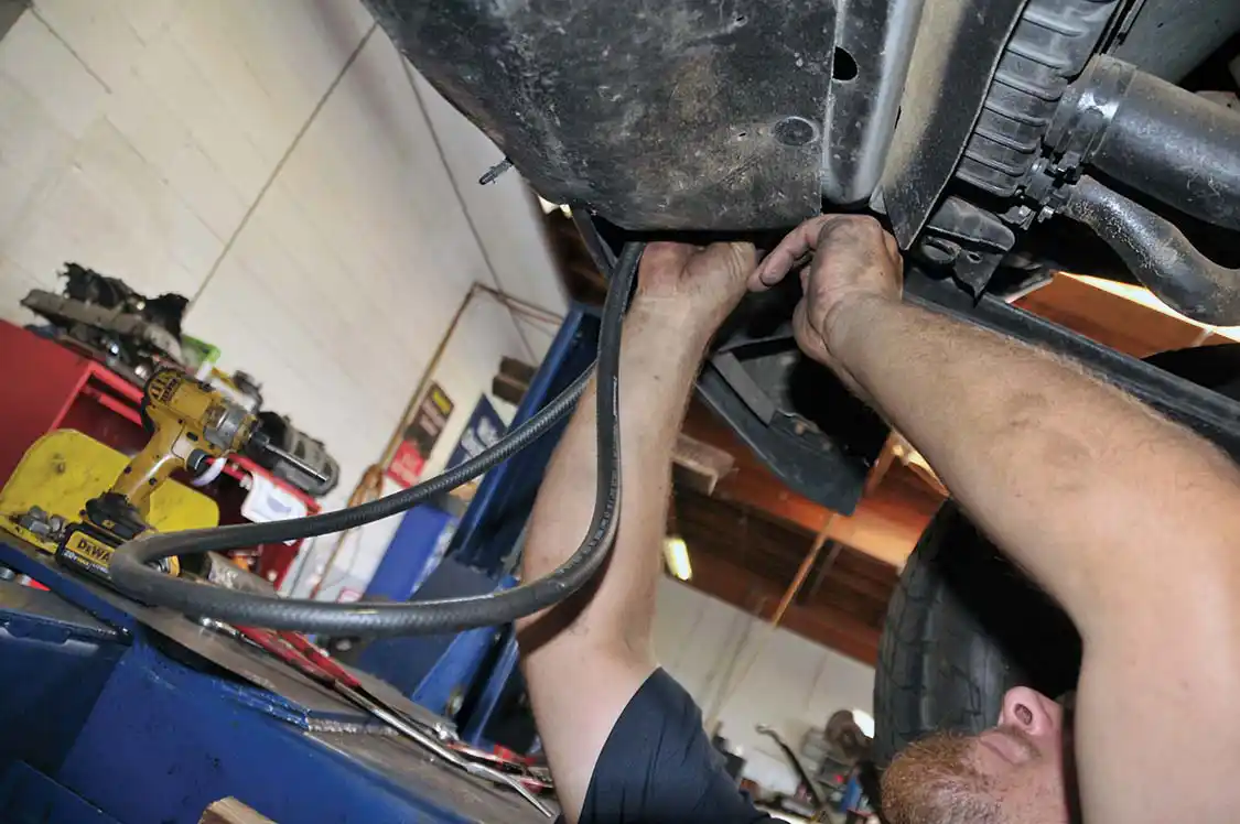 21. Underneath the truck, Cory wound the hose through a variety of obstacles to get to the factory lines.