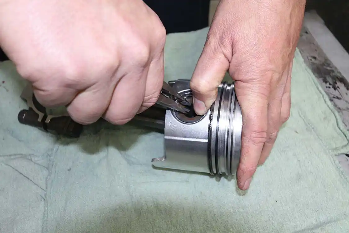 14. The piston rings are installed and then the ring gap is checked. The rods can then be installed on the pistons. Our 7.3L diesel uses snap rings to retain the pins and the pins easily slip into place. Other engine applications require a press fit of the piston pins.