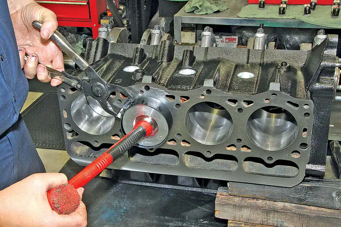 20. With the crank in place, the block can be flipped on its side and the piston and rod assemblies installed, one bank at a time. If doing the work yourself, take care to not scratch the crank journals with the rod cap studs during assembly.