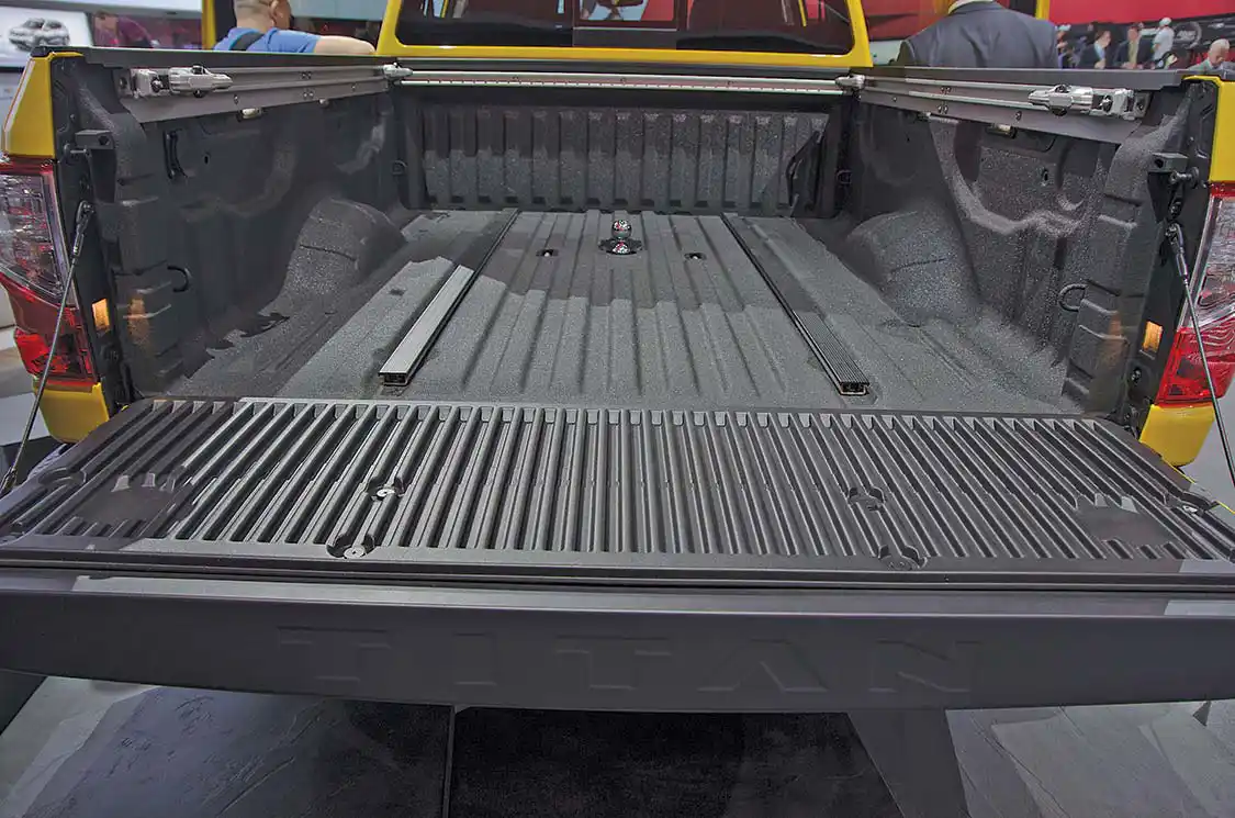 Fully coated and protected, the PRO4X bed looks ready to go to work. This show model has the gooseneck hitch and security chain attachments exposed. A close look at either side will show lamps shining down onto the bed for nighttime work.