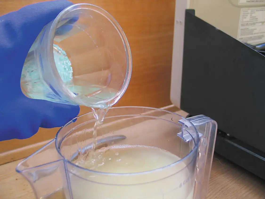 6. Add the methyl alcohol and lye mixture to the plastic container. Do this slowly to avoid splattering or spilling, and make sure to wear rubber safety gloves at this point.