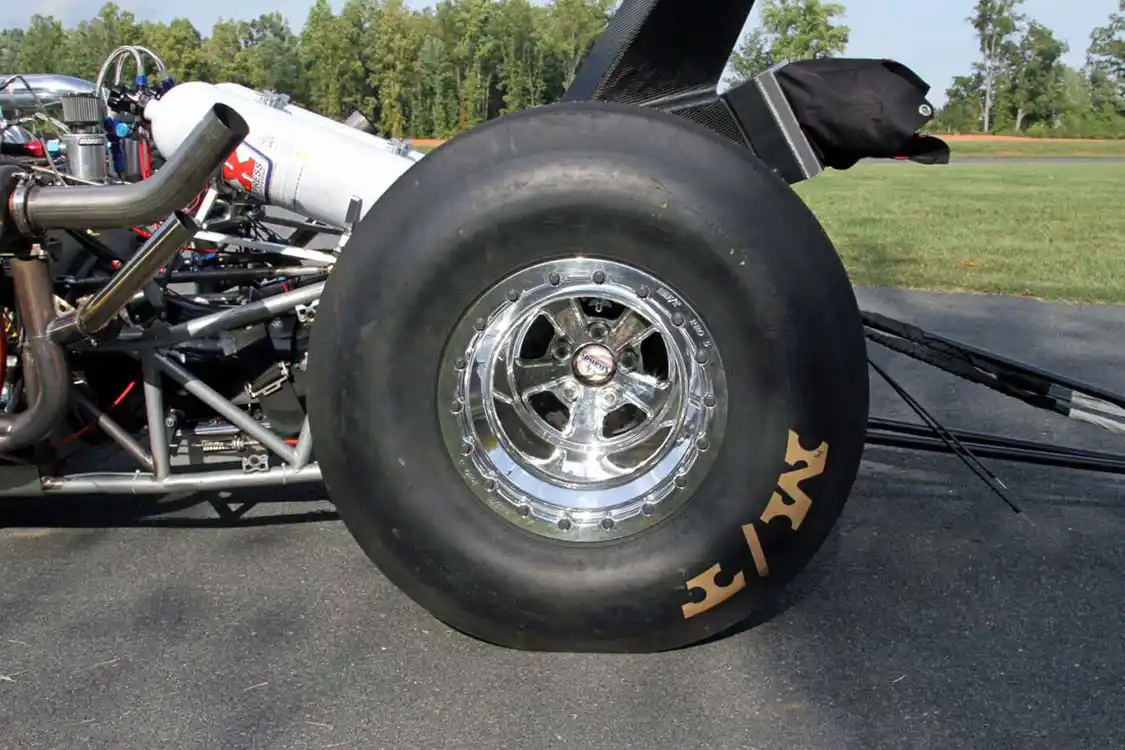 Massive 35.0/15.0-16 <a href="https://mickeythompsontires.com/wheels">Mickey Thompson</a> ET Drag slicks are securely held in place on the double beadlock Mickey Thompson Pro 5 wheels. You can also see the ends of the <a href="https://www.strangeengineering.net/">Strange Engineering</a> axle shafts that deliver the power to the wheels.