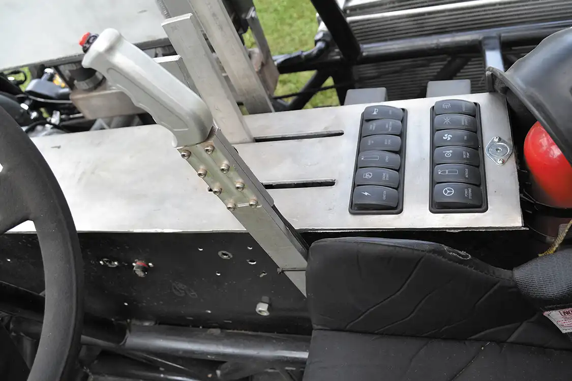 The interior of the puller is sparse and functional. The lever to the right of the steering wheel is a hand throttle, which allows very precise control of the engine, especially on rough tracks. The OEM-style buttons on the switch panel were custom made, so were control things like the lighting, ignition and fuel pump.