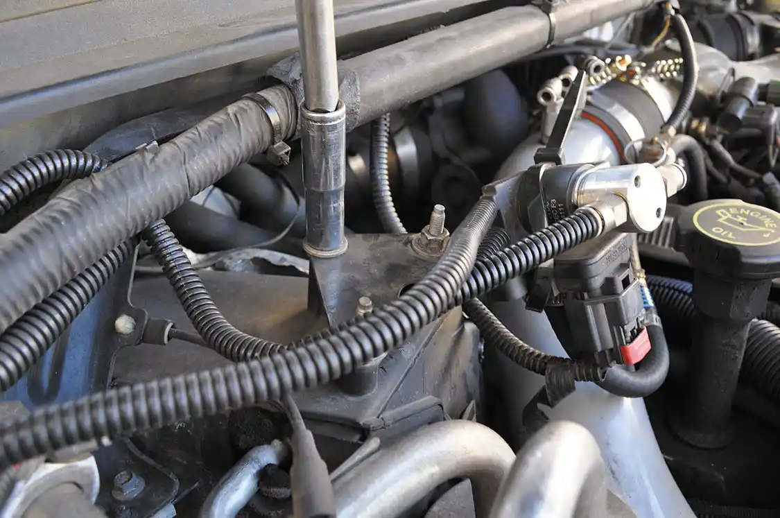 9. Next the MAP (Manifold Absolute Pressure) sensor and bracket were removed using a 10mm socket wrench. Pulling the two together allows for much needed room to remove the cold side intercooler pipe. At this time we also disconnected the water methanol injection lines as well as boost signal lines for the trucks gauges.