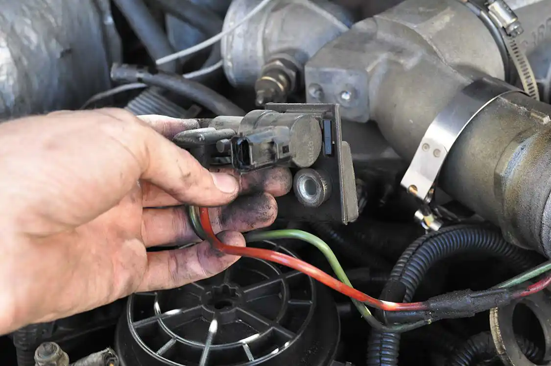 11. The 7.3’s intake manifold (a.k.a “intake spyder”) must be removed to access the turbo. Seen here the wastegate control solenoid is unplugged, and removed. Two lines (green from the intake, red from the wastegate), a single electrical plug and an 8mm bolt are all that need be disconnected.