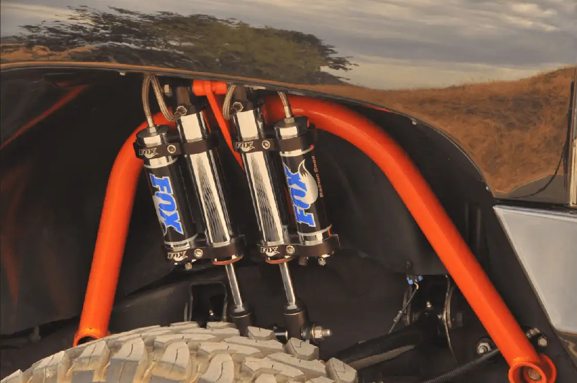 Dual <a href="https://www.ridefox.com/">Fox</a> remote reservoir shocks mounted on a Cognito double-shock hoop control the ride on the front.