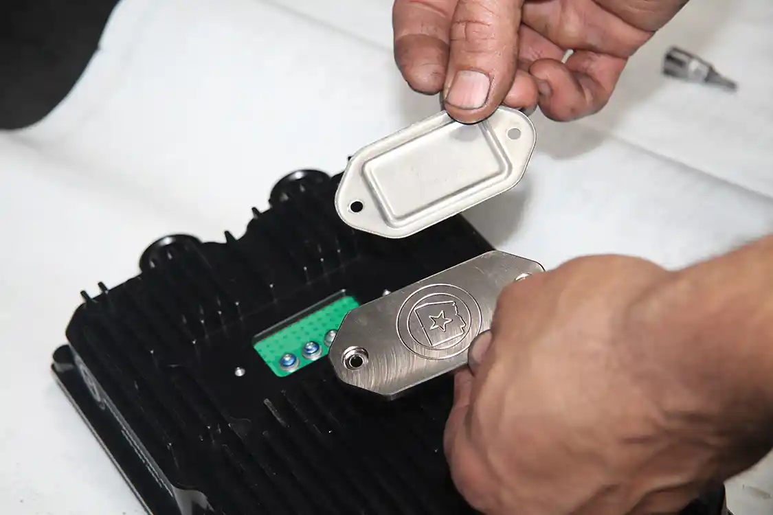 13. Here you see the OEM inspection plate and the new billet aluminum one from Bullet Proof.