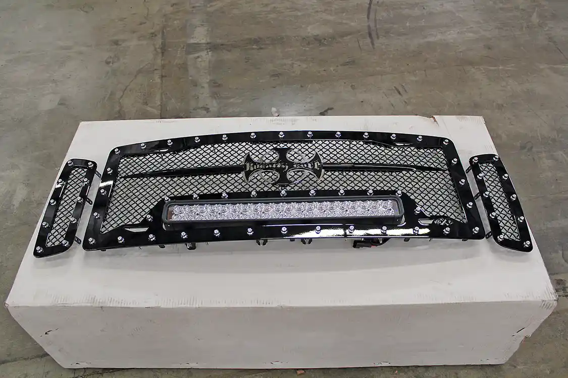 1. We decided to take a two-pronged approach to our truck’s new nose. The first was the TrailReady bumper, installation of which was covered in our last issue ( Diesel World, December 2014). The second is a Royalty Core RC1X Incredible LED grille. This three-piece insert includes a gloss black mesh grille surround with nickel-plated stud accents around all three pieces. The center portion includes a 22-in. Vision X LED light bar on adjustable mounts with an included wiring kit. The grille feels solid and well constructed, with TIG welding and stainless steel mounting hardware.