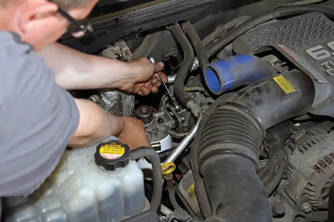 25. After installing the spacer, the bolts are fully tightened to secure the filter assembly to the engine.