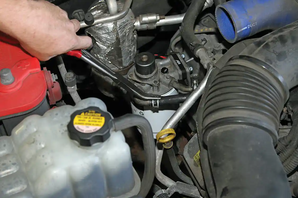 26. The next step is to reinstall the inlet and outlet fuel lines and slide the clamps into position to secure the fuel lines.