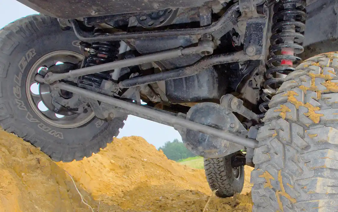 The Comanche conversion dictated some changes to the front suspension. Being pretty adept with the old “hot metal glue gun,” Bankston built a custom belly pan, to which he attached a pair of <a href="https://www.tntcustoms.com/">TNT Customs</a> Y-link control arms and 9-inch lift coils, which were compressed down to a 4.5-inch lift by the weight of the diesel. <a href="https://www.bilstein.com/us/en/">Bilstein</a> 5150 shocks were used with a custom track bar and a 1-ton GM steering system, ZJ pitman arm and a custom steering box brace for the Dodge Durango steering box.