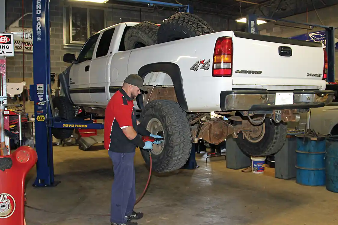 1. To start the Ultimate Rear Axle Build Jason Nelson puts the big <a href="https://www.dmaxengines.com/">Duramax</a> truck on one of the twin post lifts in the RPM Offroad service bay and then removes the rear wheels.