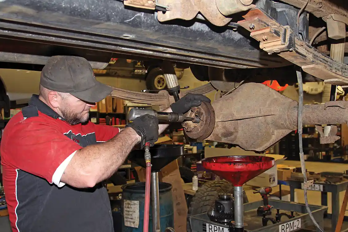 9. Nelson uses an air hammer with a punch attachment to remove the pinion gear from the housing then drives out the bearing races that will be replaced along with the bearings from the G2 master installation kit.