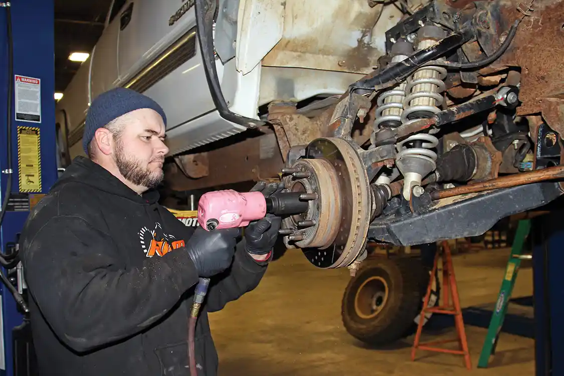 1. At RPM Offroad Jason Nelson starts the installation by putting our 2001 Chevy on the lift, removing the front tires, and removing the CV axle nut behind the factory dust cover.