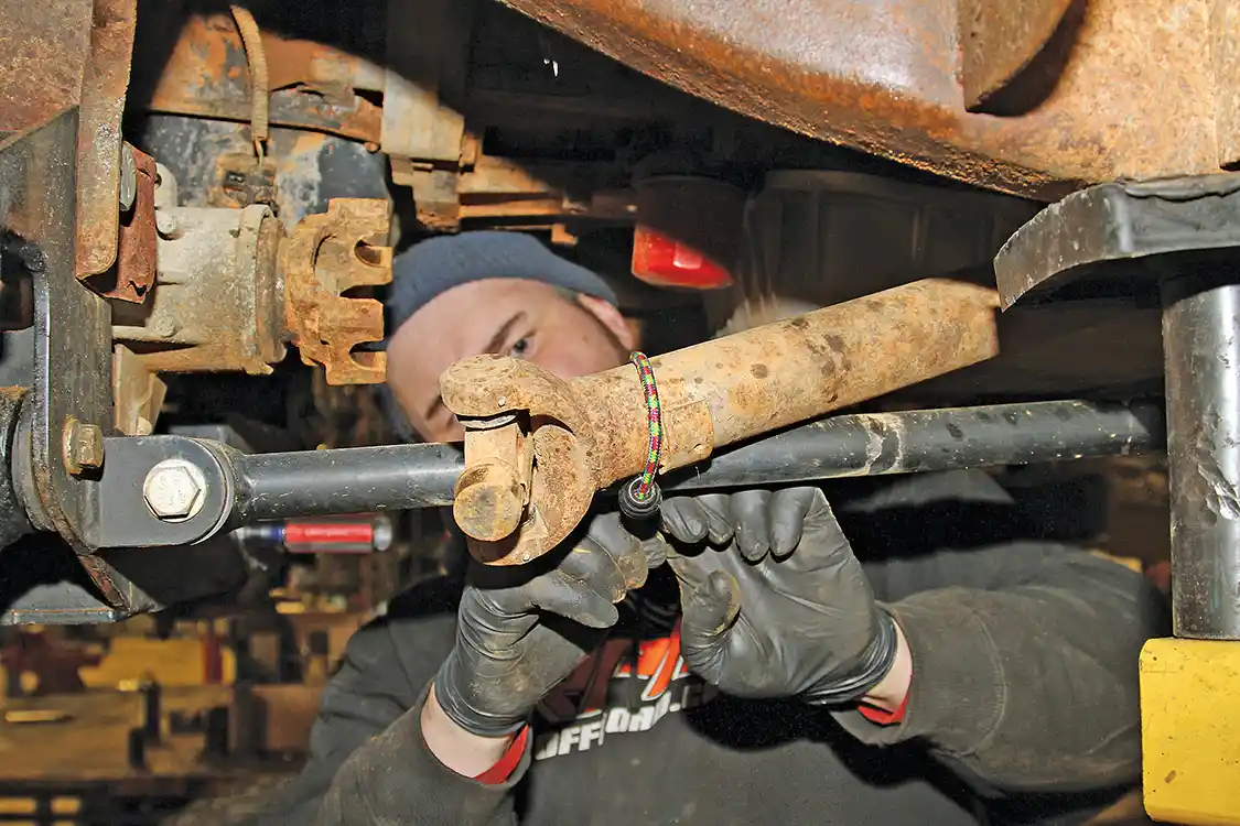 4. With the CVs removed, Nelson disconnects and secures the front driveshaft and unplugs the differential harness before unbolting the mounting hardware for the differential assembly.