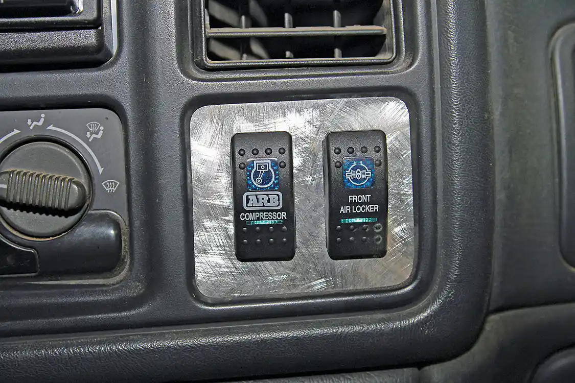 35. Nelson made an aluminum panel to house the switches in the dash slot below the A/C vent. Michael Powell installed the switch panel and wired the ARB system so that the compressor and Air Locker can be operated only when the ignition is on; additionally, the compressor must be on to operate the locker. Use care to avoid activating the locker when driving as steering will be very difficult, if not impossible, on pavement.