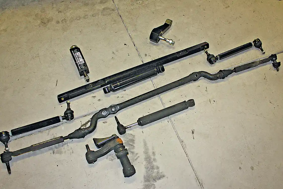11. The entire factory steering assembly (bottom) was removed from the truck and laid out next to the new Ultimate Steering Package (top) from Dmax Store. The center link is sturdy and the tie rods are designed to stand up to abuse.