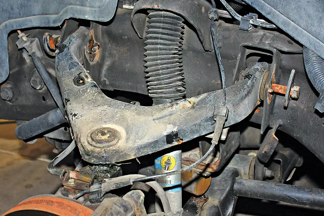 5. Changing the upper control arms is pretty simple but will require a ball joint fork to separate the stock UCA from the knuckle. Plus, you’ll need to get into a qualified shop for an alignment afterwards. With the truck up on stands and the knuckle supported by a jack, you just need to disconnect the brake line bracket, remove the two eccentric bolts that attach the UCA to the frame, and get the ball joint broken loose.