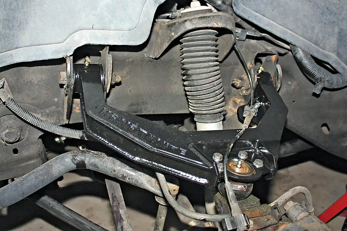 9. With the ball joint bolted to the new control arm, the assembly can be reinstalled in the truck using the original eccentric bolts at the frame rail mounts. The factory brake line needs to be routed away from any moving parts and zip-tied to the control arm. Once the bolts and ball joint nut have been torqued, the grease zerks can be added at the upper bushings and ball joint. Don’t forget to grease the new joints and get a professional alignment done. It’s also a good idea to recheck the torque on all hardware after a few miles of driving.