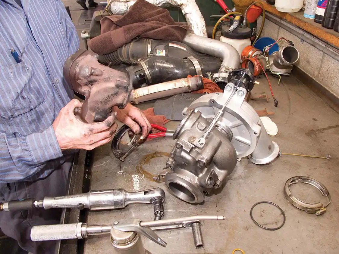10. The cast iron turbo adaptor is swapped from the stock turbo to the new unit. This adaptor connects the turbo to the right and left up-pipes.
