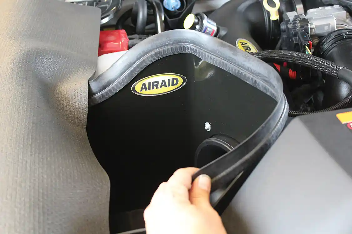 11. With the installation largely complete, the weatherstripping can be installed on the top edge of the air box. Another installation tip: if you spread the channel in the weatherstripping slightly by running the blade of a small screwdriver through it, it’s much easier to push the weatherstripping on to the box edge and make all of the corners. This weatherstripping is important because it seals against the underside of the hood, which keeps hot engine air away from the filter.