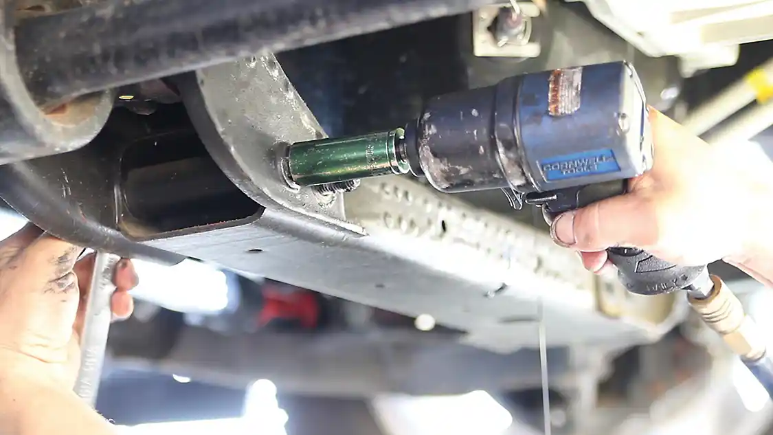 1. Your first step is to raise the truck to gain access to the pan. This can be done with jack stands or on a lift. Removing the front wheels will allow better access, especially if you’re doing the work on the ground. Next, drain the oil. Be sure to replace the drain plug. There’s still old oil in that hump in your stock pan. You don’t want that spilling on you when you dislodge the old lower pan. One tip is to also remove the old oil filter at this time as that will help drain the engine of oil too. You can now remove the skid plates and crossmember to get access to the entire lower oil pan.