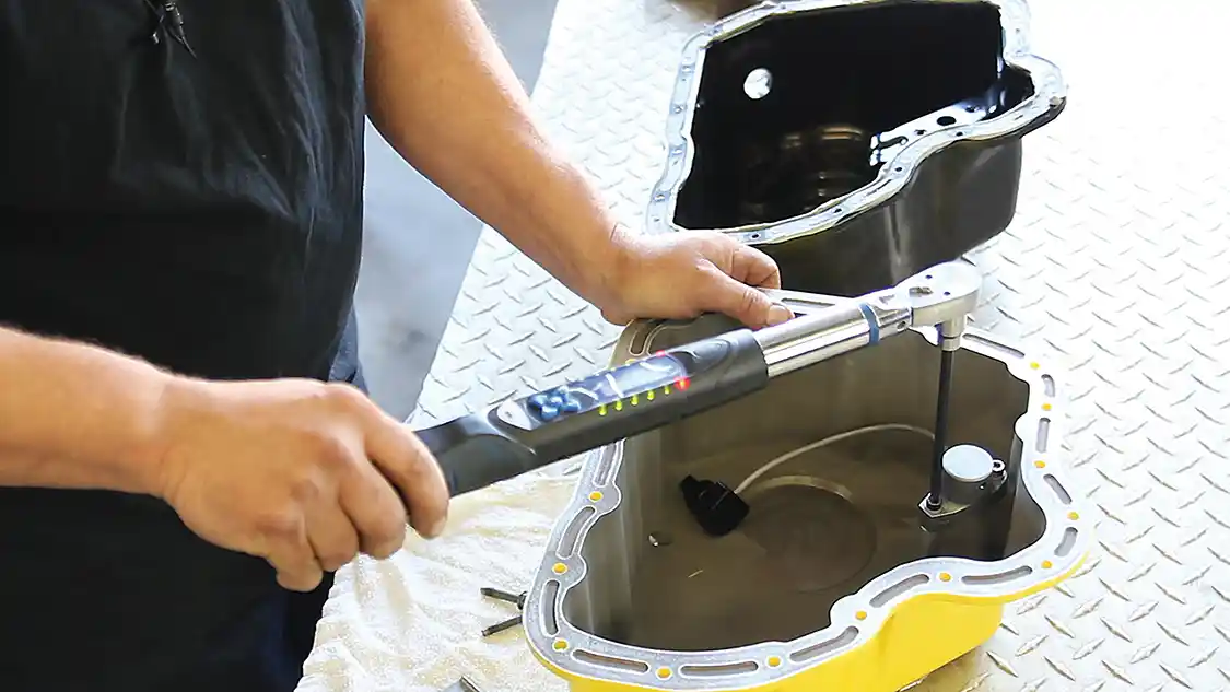 6. While the engine is draining, you can prep the Banana Pan for installation. The low oil sensor is installed and secured in place.