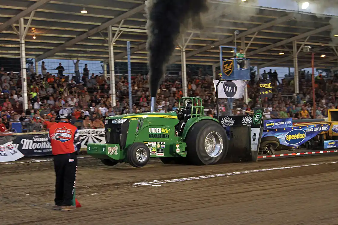 John Sharp piloted his highly modified <a href="https://www.deere.com/en/index.html">John Deere</a> tractor to the Scheid Diesel Extravaganza win in the Pro Stock Tractor class.