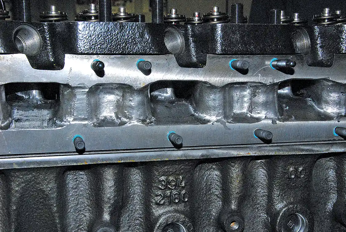 12. The Diesel Club machined off the cast intake manifold and did some mild porting. They drilled and tapped the head for a new manifold.
