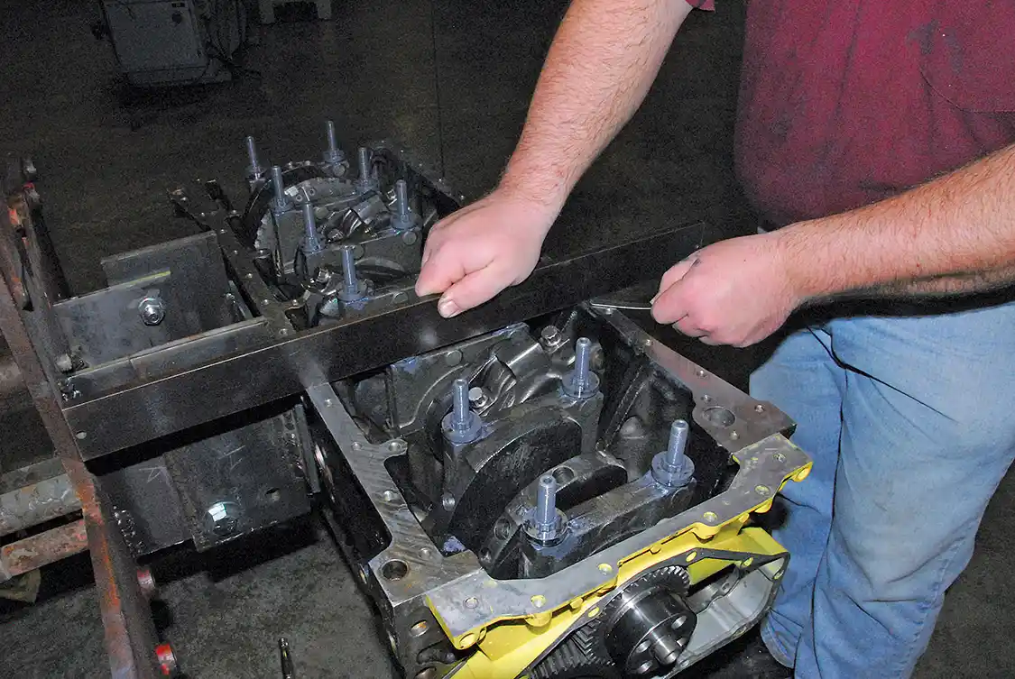15. The Haisley Gorilla Girdle requires extra-long main studs. After installing the special washers over the nuts, a straightedge is used to make sure the washers are within 0.015 inch of even with the pan rail.