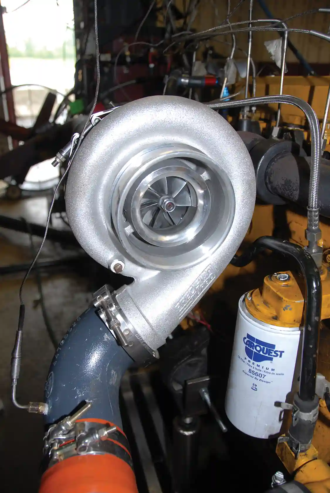 6. The Precision Turbo 2.6 x 3.35 turbo is designed 2.6-class pulling trucks. The numerals in the name refer to the diameters of the compressor and turbine. In this particular turbo, the purchaser can choose between two A/R (Area/Radius), 1.12 or 1.28. A/R describes the size of the turbine housing; a smaller housing will spool up faster but have more restriction than a larger A/R. Low-revving engines should use the 1.12, but this being a high-revver, the UNOH Diesel Club used the 1.28. The Precision compressor wheels are CNC-machined 2618 alloy forged aluminum while the turbine is made of Inconel.